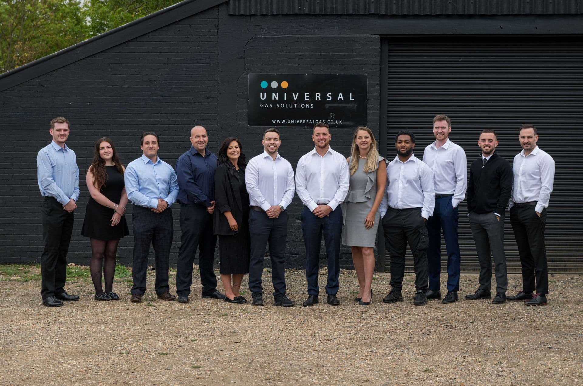 The whole Universal team standing outside the office building