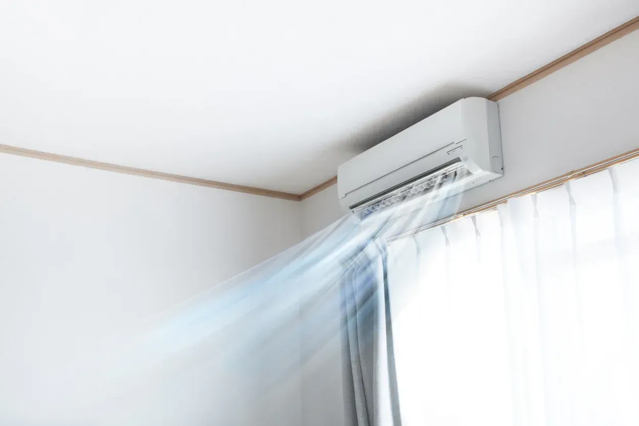 A wall-mounted air conditioning unit in a bright room